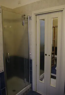 a shower with a glass door in a bathroom at Tucci's Roma Guest House in Rome