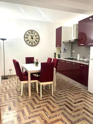 a kitchen with a table and chairs and a clock on the wall at Dimora Sistina Roma in Rome