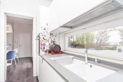 a white kitchen with two sinks and a window at Elegant apartment metro A - by OpenRoma in Rome