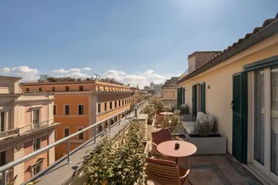 a balcony with a table and chairs and buildings at Cloud 7 Roma Hotel in Rome