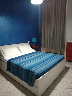 a bedroom with a bed with a blue wall at Repubblica Apartment in Rome