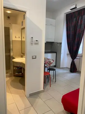 a room with a kitchen and a dining room with a table at La perla del Colosseo in Rome