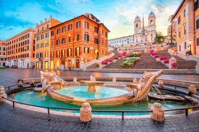 a fountain in the middle of a street with buildings at Luxury apartments, Piazza di Spagna in Rome