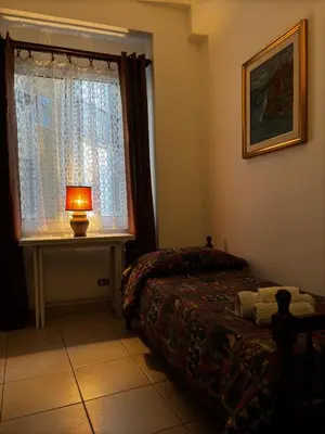 a bedroom with a bed and a table with a lamp at Vodice Apartment- Between Vatican and Foro Italico in Rome