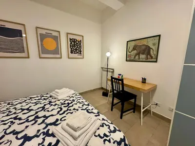a bedroom with a bed and a desk with a chair at Trastevere Cozy Retreat in Rome