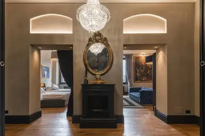 a living room with a chandelier and a fireplace at Mega Royal Suite in Rome