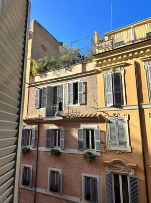 a tall brick building with windows and a balcony at Tata Home Monti in Rome