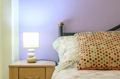 a lamp on a night stand next to a bed at 