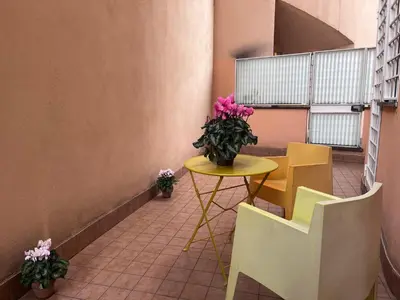 a table and chairs and a vase with flowers on it at Sweet Home Cavalese, Cortina d'Ampezzo, Università Cattolica, Gemelli in Rome