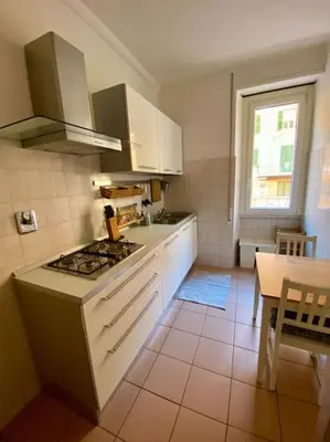 a kitchen with a stove and a table in it at Lovely Apartment near metro A Re di Roma in Rome