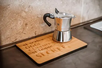 a coffee pot sitting on a wooden cutting board at Casa Martini - Vatican City and Metro Ottaviano in Rome