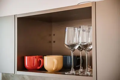a cupboard with four wine glasses in it at Casa Martini - Vatican City and Metro Ottaviano in Rome