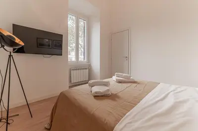a white bedroom with a bed with towels on it at Casa Martini - Vatican City and Metro Ottaviano in Rome