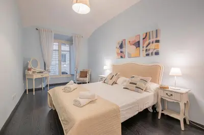 a white bedroom with two beds and two tables at Apartment In Via Merulana Central Rome by Halldis in Rome
