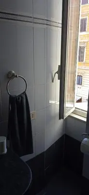 a bathroom with a black towel hanging on a wall at InsideRome Appartamento Vaticano e Centro Storico in Rome