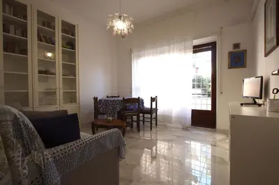 a living room with a couch and chairs and a television at Graziano Holiday House in Rome