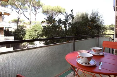 a red table with two cups on a balcony at Graziano Holiday House in Rome
