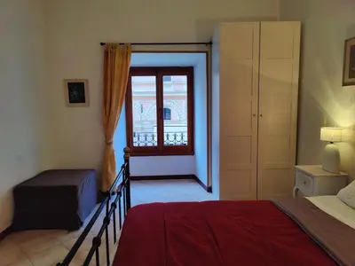 a bedroom with a bed and a door to a window at Appartamento Gracchi 15 in Rome