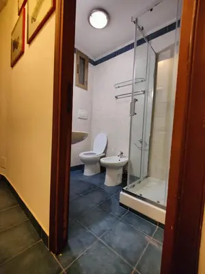 a bathroom with a toilet and a glass shower at Appartamento Gracchi 15 in Rome