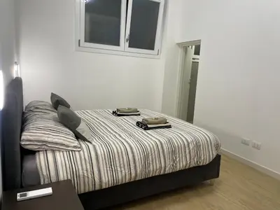 a bed in a white room with two phones on it at Condottieri's Hidden Home - Metro C direct to Colosseum in Rome