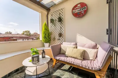 a balcony with a couch and a table at Comics Roma Penthouse, Funny Flat Nearby Colosseum in Rome