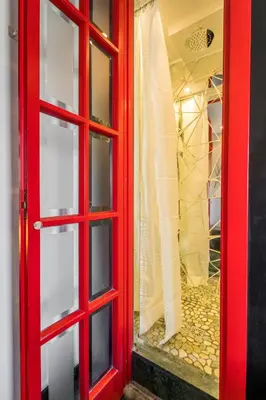 a red door with a window with a wedding dress at Comics Roma Penthouse, Funny Flat Nearby Colosseum in Rome