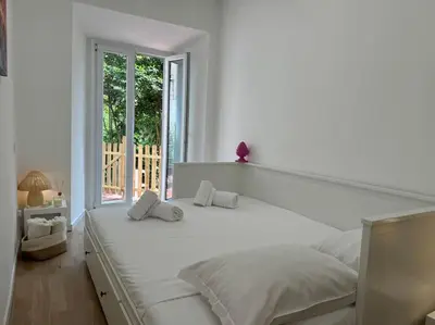 a white bedroom with a large white bed with two pillows at Camelia's Garden in Rome