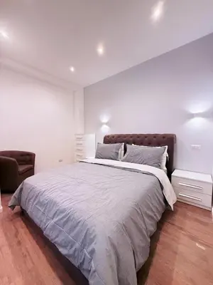 a white bedroom with a large bed and a chair at TRASTEVERE PALACE GUEST House in Rome