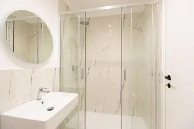 a white bathroom with a sink and a shower at TRASTEVERE PALACE GUEST House in Rome