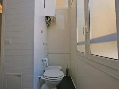 a bathroom with a white toilet and a window at Suite Cernaia Holidays in Rome