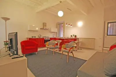 a living room with red chairs and a kitchen at Suite Boschetto Holidays in Rome
