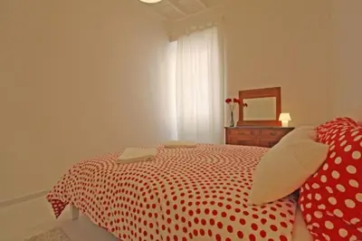 a bedroom with a red and white bed with a mirror at Suite Boschetto Holidays in Rome