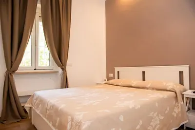 a bedroom with a white bed and a window at Gozzadini Apartment in Rome