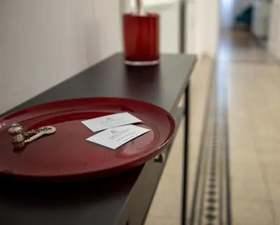 a red plate on a table with a ticket on it at UrbanPiramide - Roma in Rome