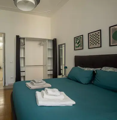 two towels on a blue bed in a bedroom at UrbanPiramide - Roma in Rome
