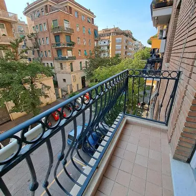 a railing on a balcony with buildings and trees at Giovanni Home Porta Metronia in Rome