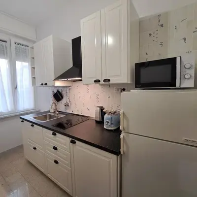 a kitchen with a white refrigerator and a sink at Giovanni Home Porta Metronia in Rome