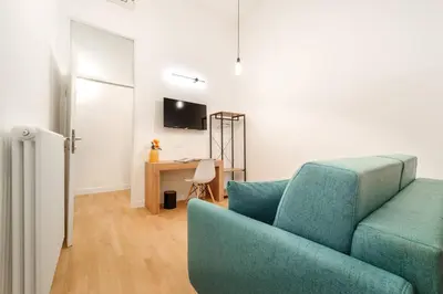 a living room with a blue couch and a desk at Casa Trilussa Luxury House with Terrace in Trastevere in Rome