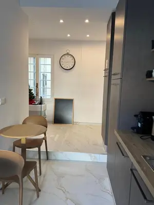 a kitchen with a table and a clock on the wall at NeW!The Place Vaticano 278 guest house in Rome