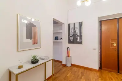 a living room with a table and a wooden door at 2 minutes from the Colosseum - Luxury apartment in Rome