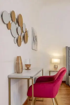 a room with a table and a red chair at 2 minutes from the Colosseum - Luxury apartment in Rome