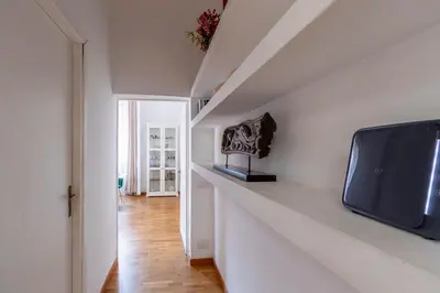 a living room with a tv on a white wall at 2 minutes from the Colosseum - Luxury apartment in Rome