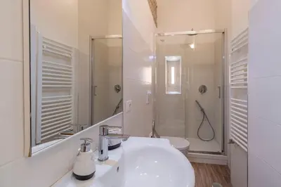 a bathroom with a sink and a toilet and a mirror at 2 minutes from the Colosseum - Luxury apartment in Rome