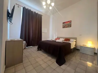 a bedroom with a bed and a chandelier at Stephany's Guesthouse in Rome