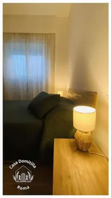 a bedroom with a bed and a table with a lamp at Casa Domitilla in Rome