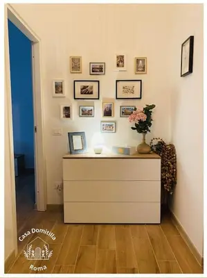 a room with a dresser with a vase of flowers on it at Casa Domitilla in Rome
