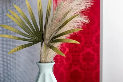 a white vase with a palm plant in it at iFlat Colosseum & Monti Cozy Bright Dream in Rome