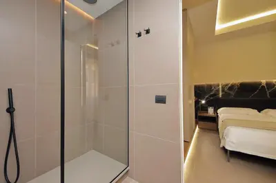 a shower with a glass door in a bedroom at Roma Suite Major in Rome