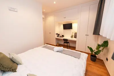 a bedroom with a large white bed and a desk at Il Melograno - Casa Palmeri in Rome