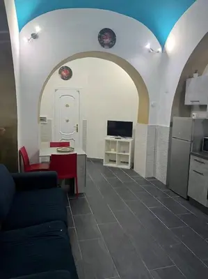 a living room with a couch and a table and a kitchen at Fenty Home 2 San Lorenzo in Rome